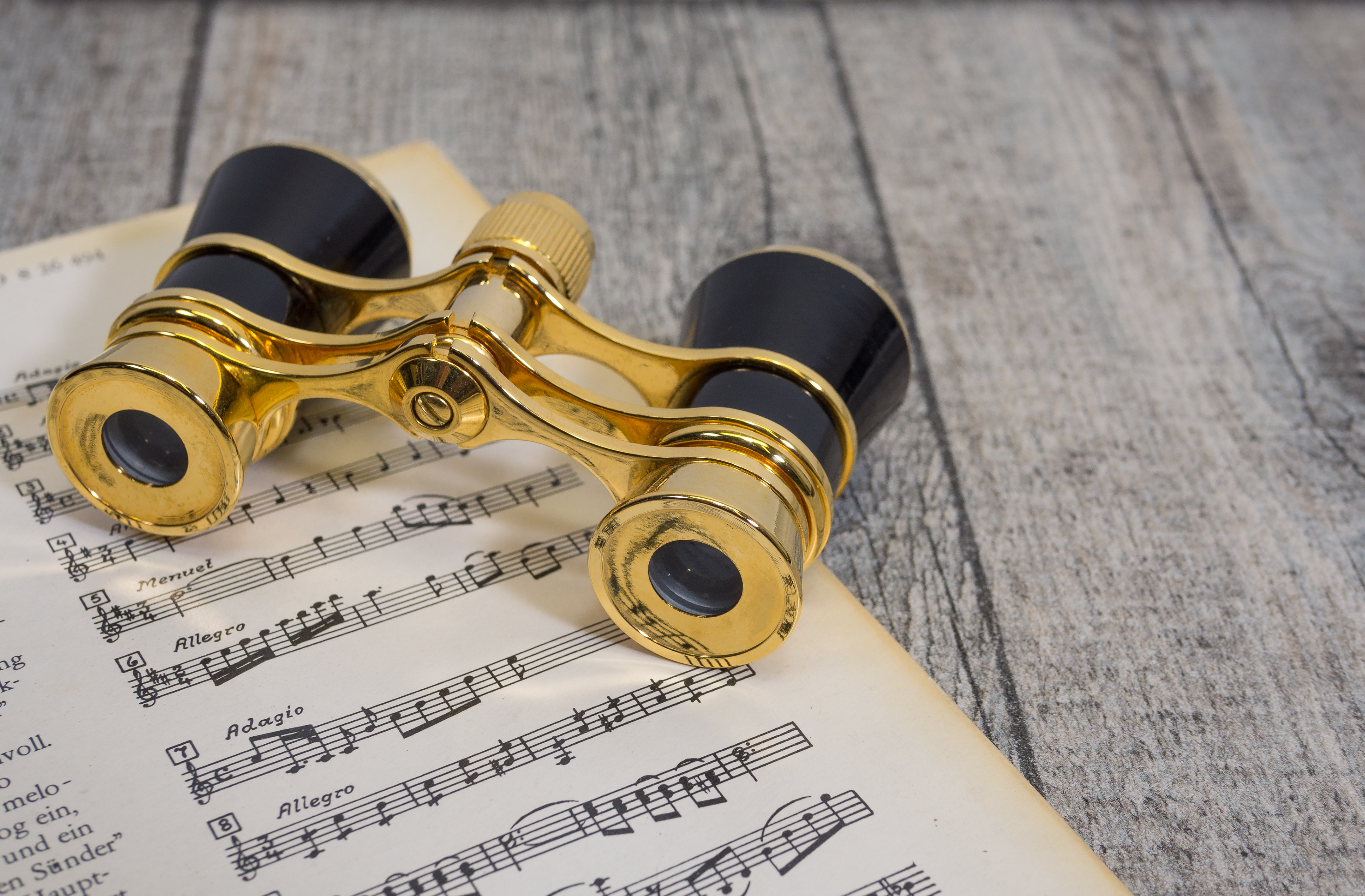 Opernglas und klassische Musikpartitur