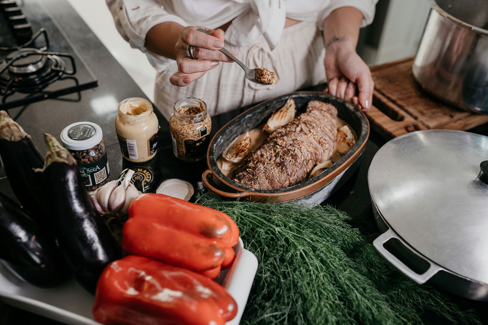 Arbeitsfläche mit Paprika, Braten und Kräutern