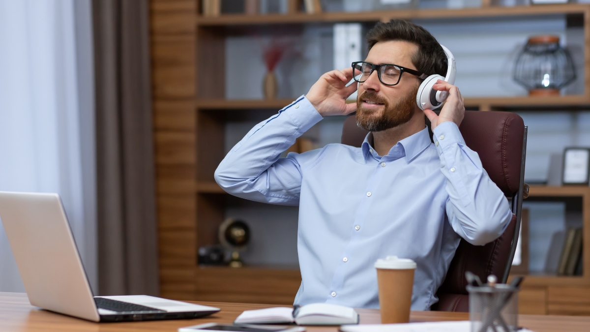 Mittelalter Mann am Schreibtisch, hört Musik und lehnt sich zurück