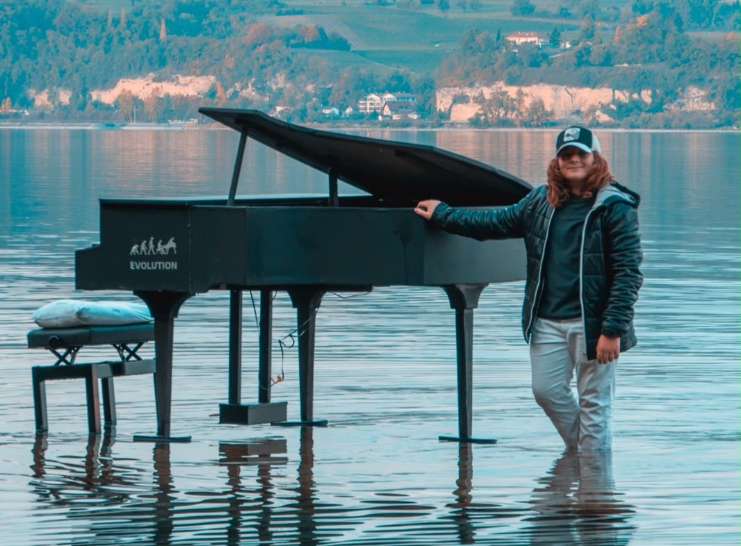 Levin Giesler steht neben seinem Klavier im Bodensee