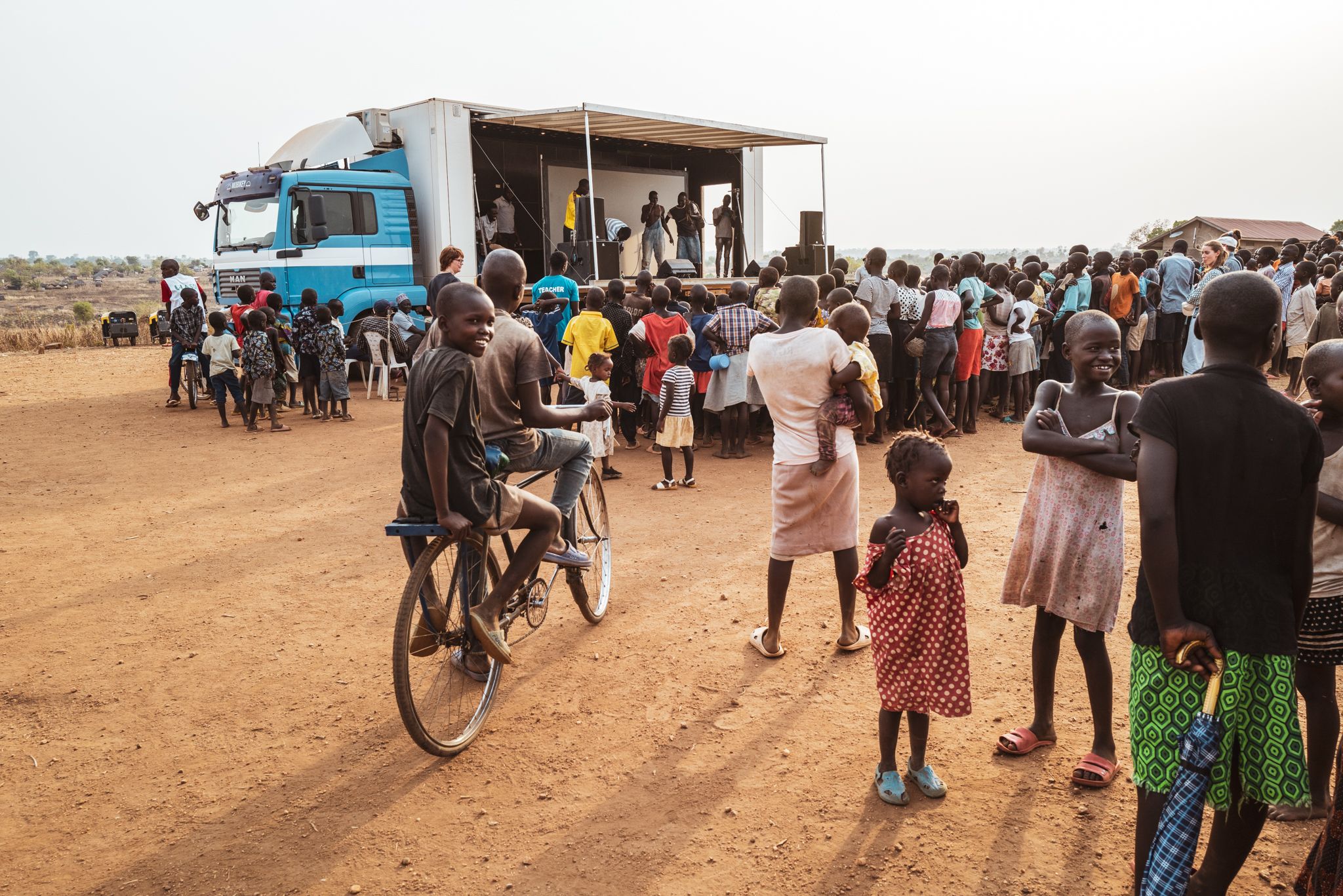 Umgebauter Truck im Hintergrund mit Menschenmenge davor