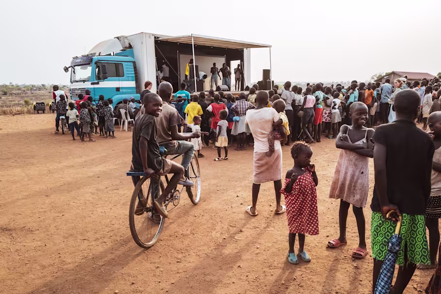 Umgebauter Truck im Hintergrund mit Menschenmenge davor