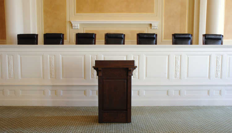 An empty judge's table in a courtroom.
