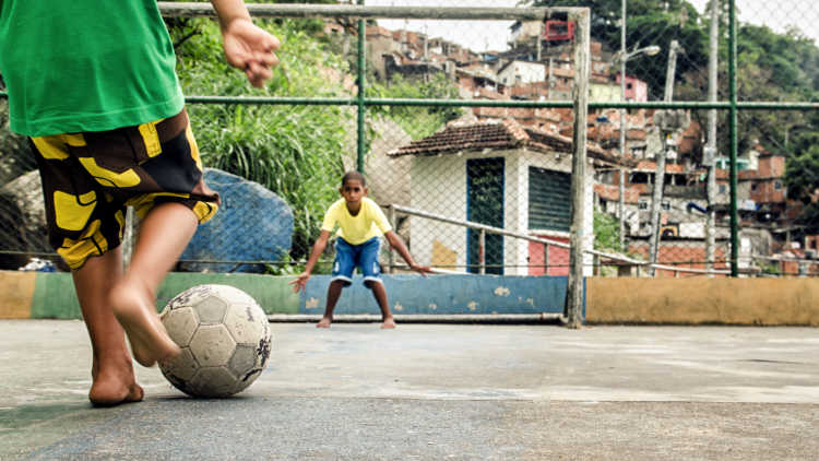 Two boys play football in Brazil