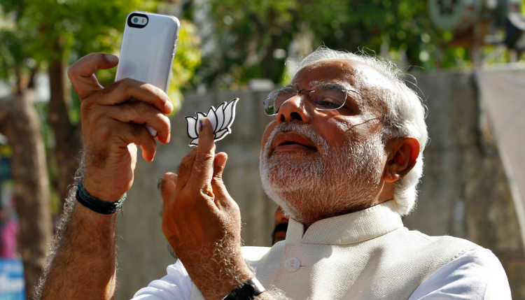 India's Prime Minister Narendra Modi takes a selfie with the flower symbol of the Bharatiya Janata Party.