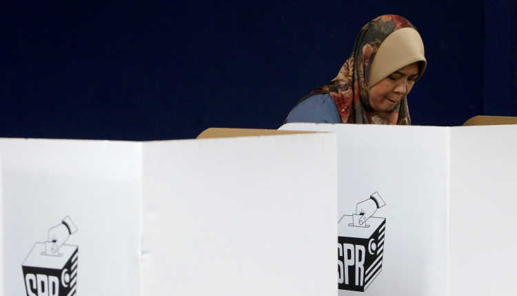 A woman votes in the elections in Malaysia.