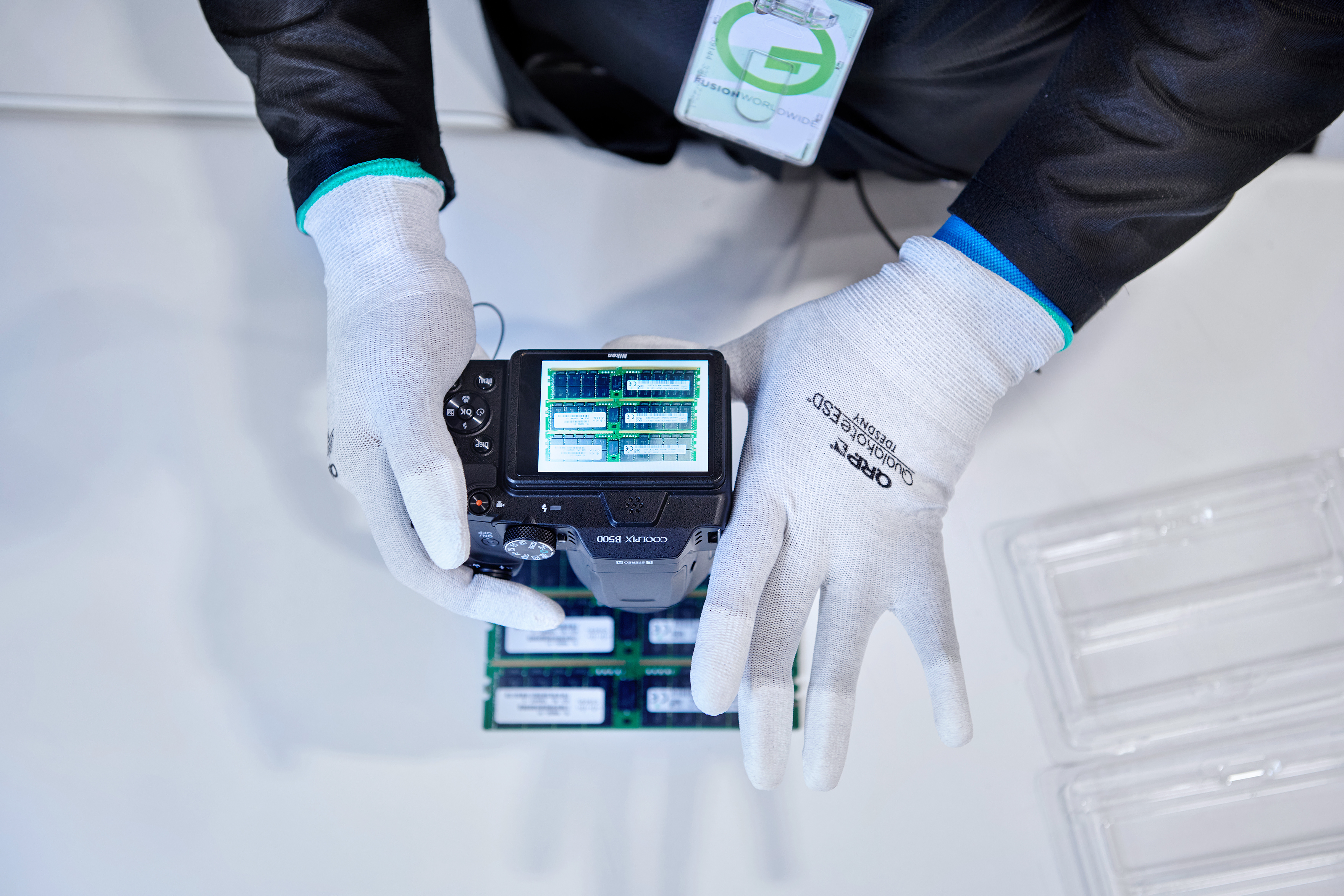 Gloved hands using an advanced camera to visually inspect electronic parts