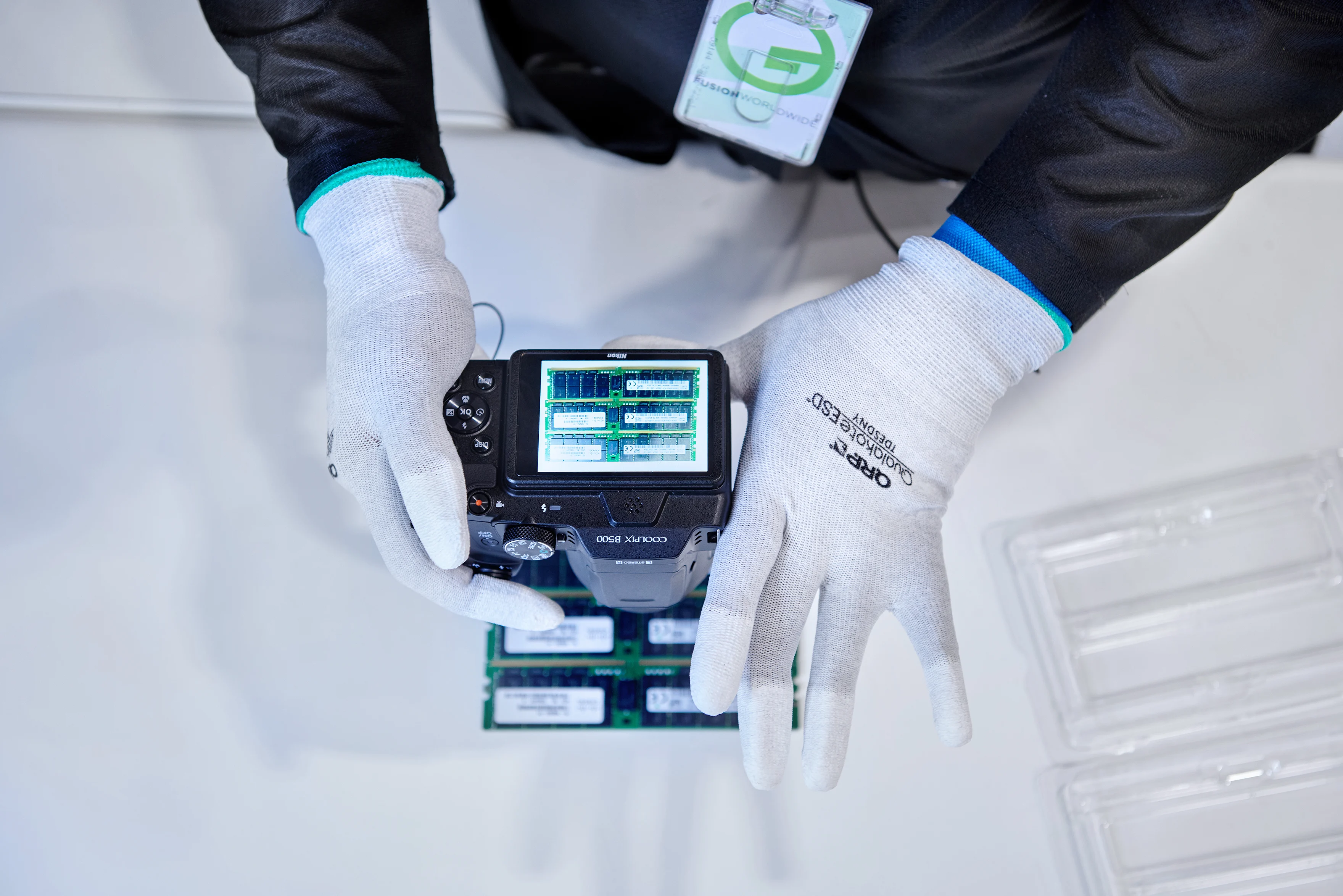 Gloved hands using an advanced camera to visually inspect electronic parts