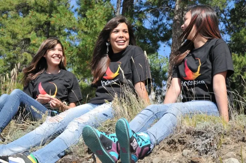 Jeunes filles souriantes portant des t-shirts arborant le logo d’Indspire