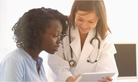 Medical professional showing a tablet to a patient.