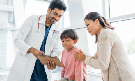 A doctor showing a tablet device to a pediatric patient and their parent.