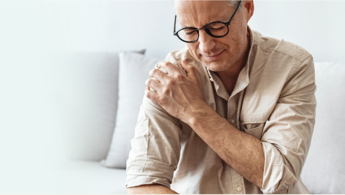 A man holding his shoulder in pain.