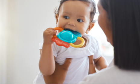 A baby playing with a teething toy