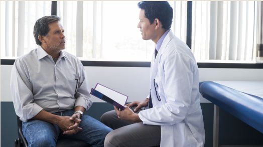 Medical professional holding a book discussing comorbidities and analgesicchoice with a patient.