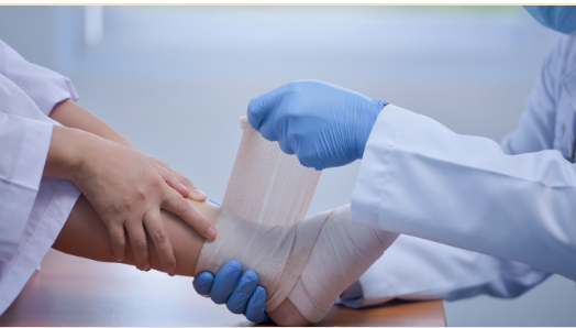 Medical professional wrapping a bandage around an ankle.