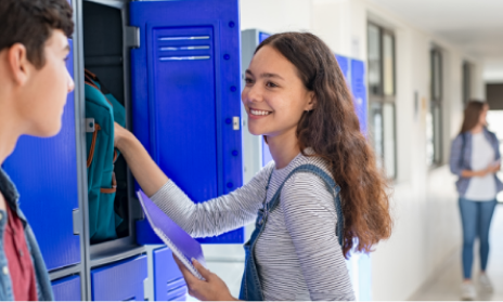 A teenager reaching into her school locker.