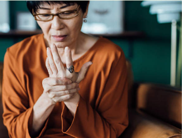 Woman with osteoarthritis massaging her hand.