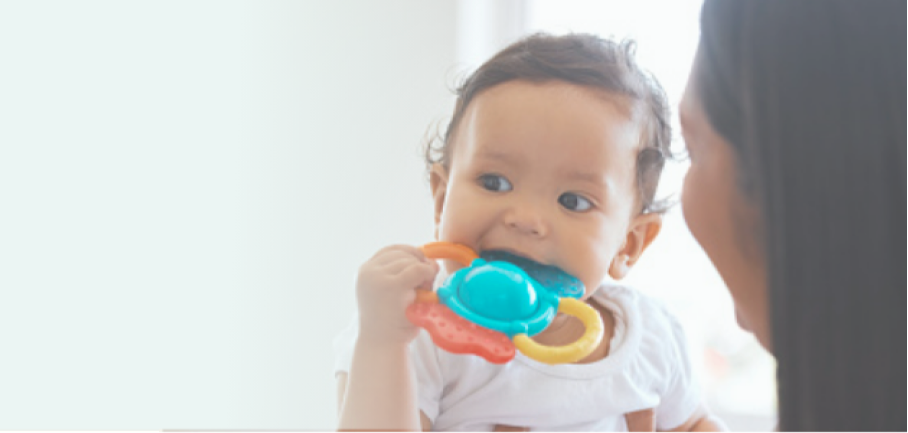 A baby playing with a teething toy.