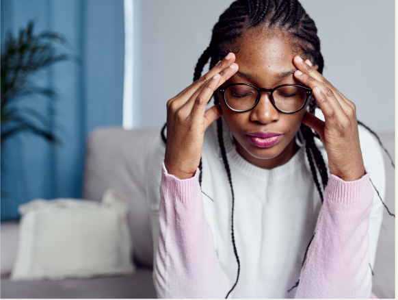 Woman with a headache rubbing her temples.