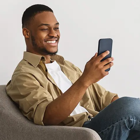 A man sitting looking at a mobile phone