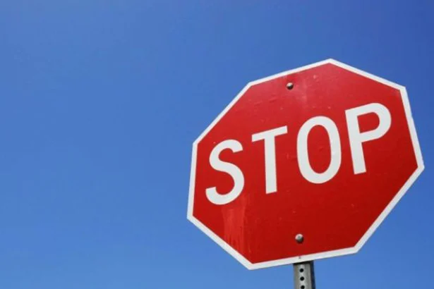 Un panneau de signalisation «STOP» devant un ciel bleu