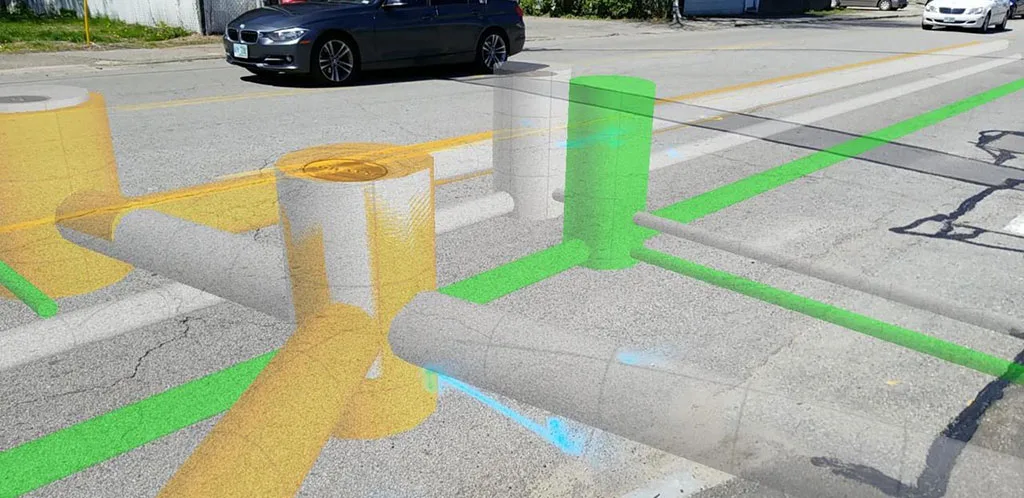 Augmented reality overlay shows underground utility pipes in yellow, green, and blue on a street.