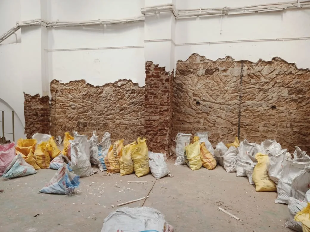 Work in progress image showing the brick wall under plaster and paint