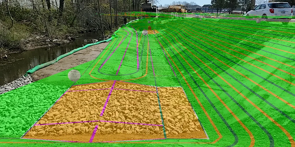 Construction site with green and orange overlay indicating landscaping plans near a body of water.