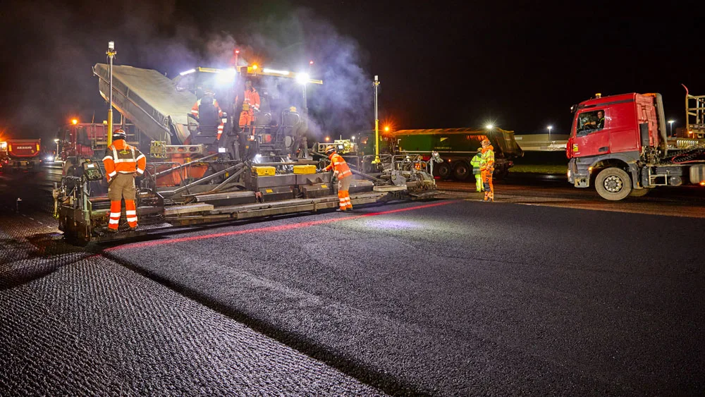 Machine and workers laying asphalt