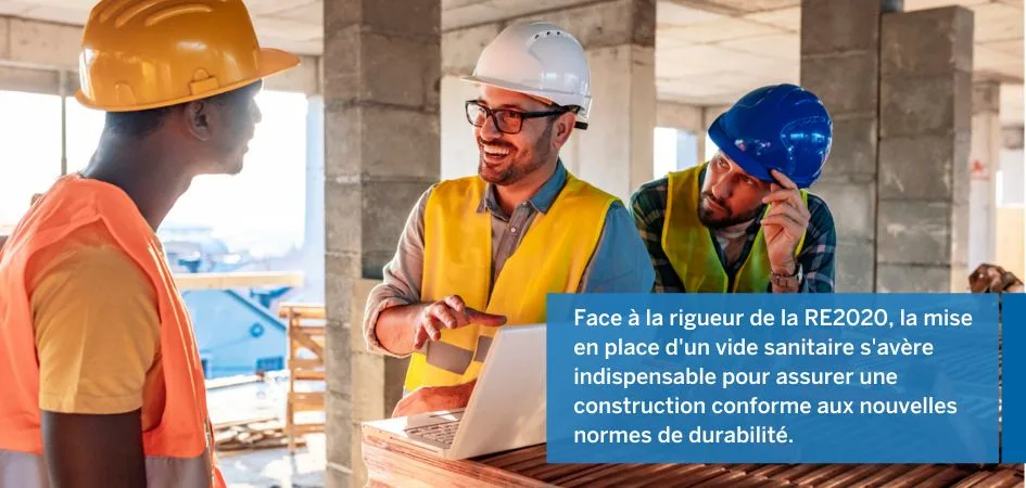 Three construction workers in hard hats and safety vests huddle around a laptop at a construction site, discussing plans.
