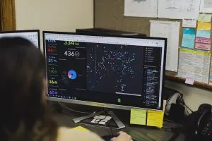 A person is looking at a computer screen displaying a dashboard with data visualizations and charts.