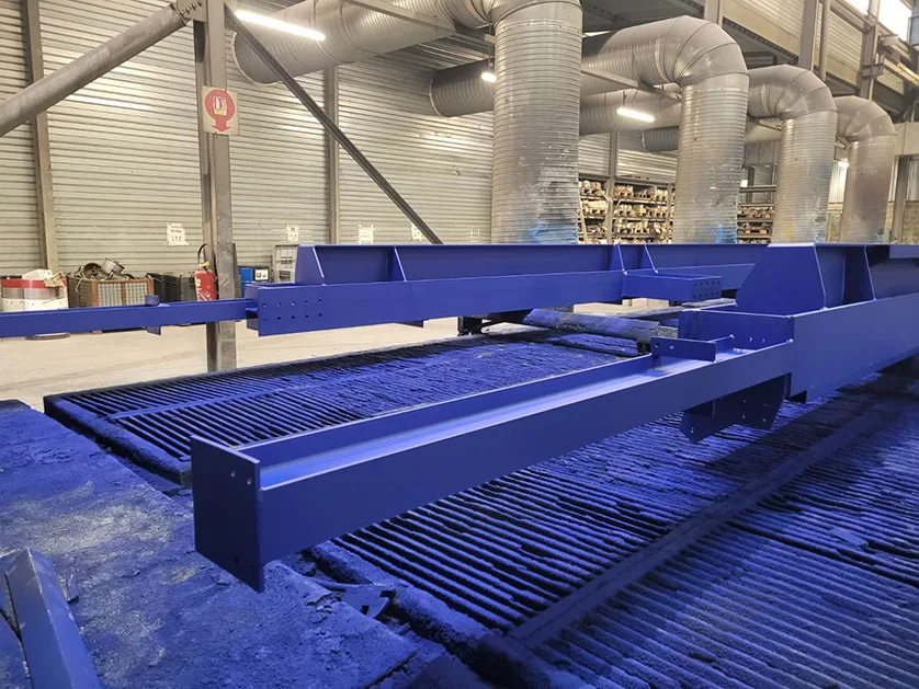 Close-up of a freshly painted blue steel structure on a powder coating line.