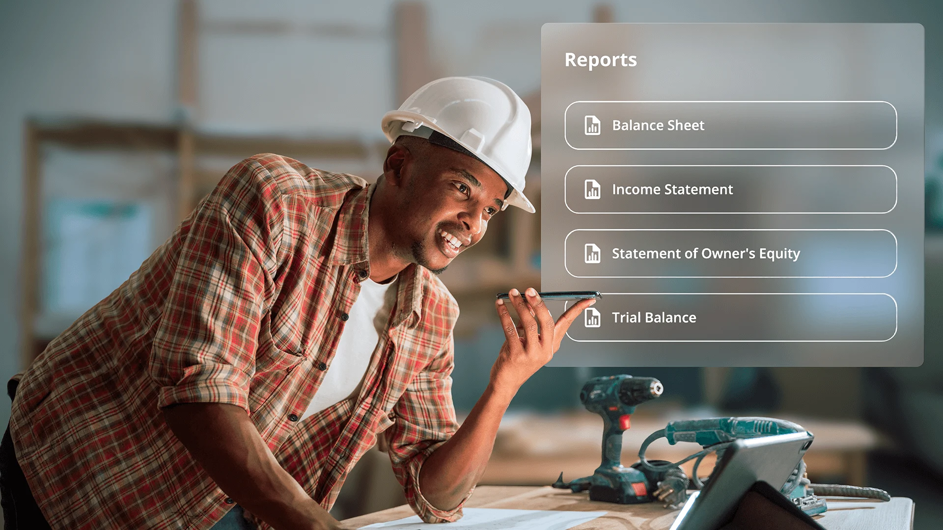 A cheerful contractor speaks into his phone in a workshop with a digital financial reports menu overlay.