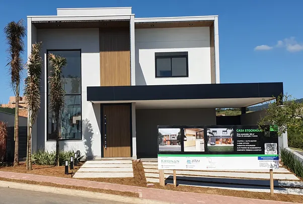 Modern two-story house with a white exterior, wooden accents, and a dark gray overhang.