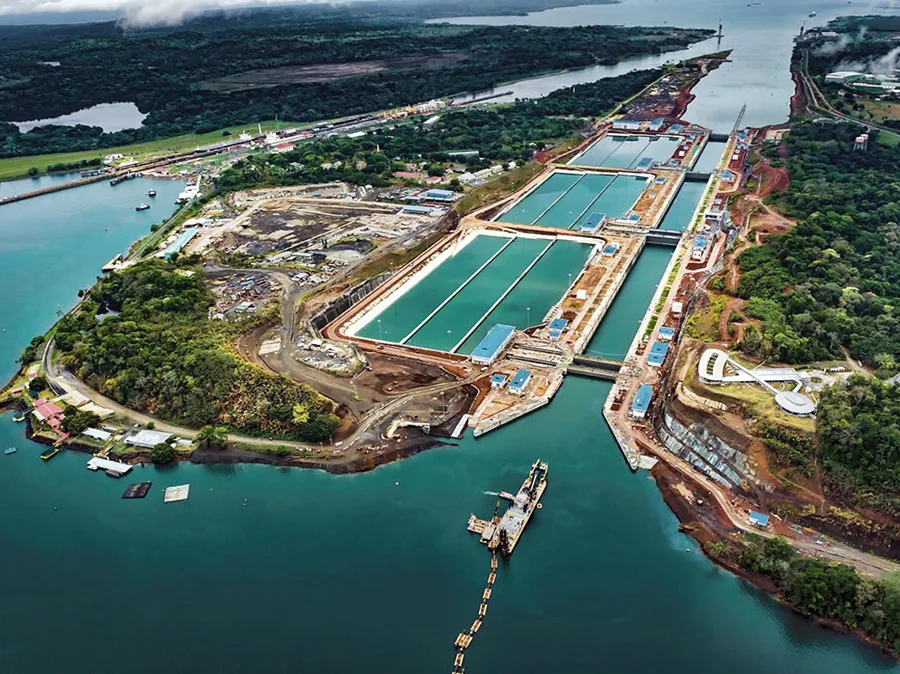 Aerial view of the Panama Canal expansion locks and waterways with lush green surroundings.