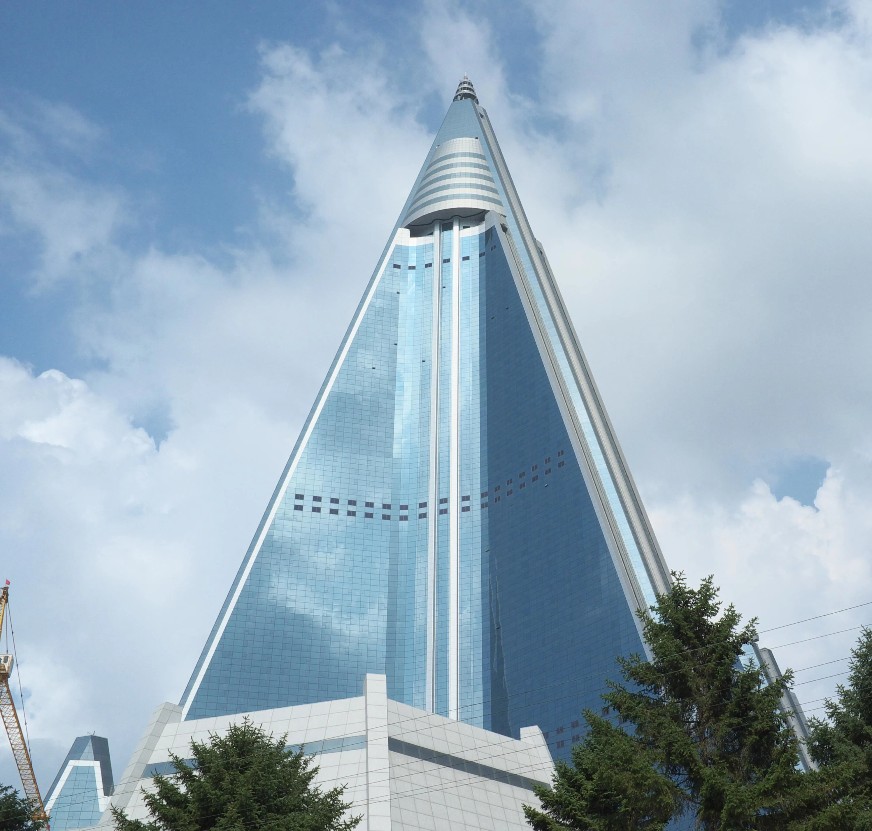 The Ryugyong Hotel, a pyramid-shaped skyscraper in Pyongyang, North Korea, under a cloudy sky.