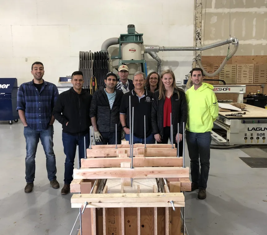 Students and construction professionals posing with a model from the Sydney Opera House research project 