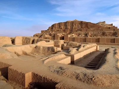 Ancient ziggurat ruins stand under a clear blue sky.