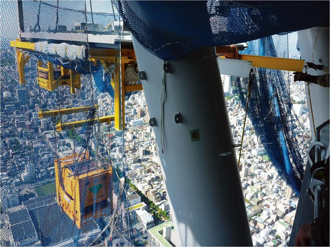 Construction of Tokyo Skytree with a cargo lift suspended mid-air.