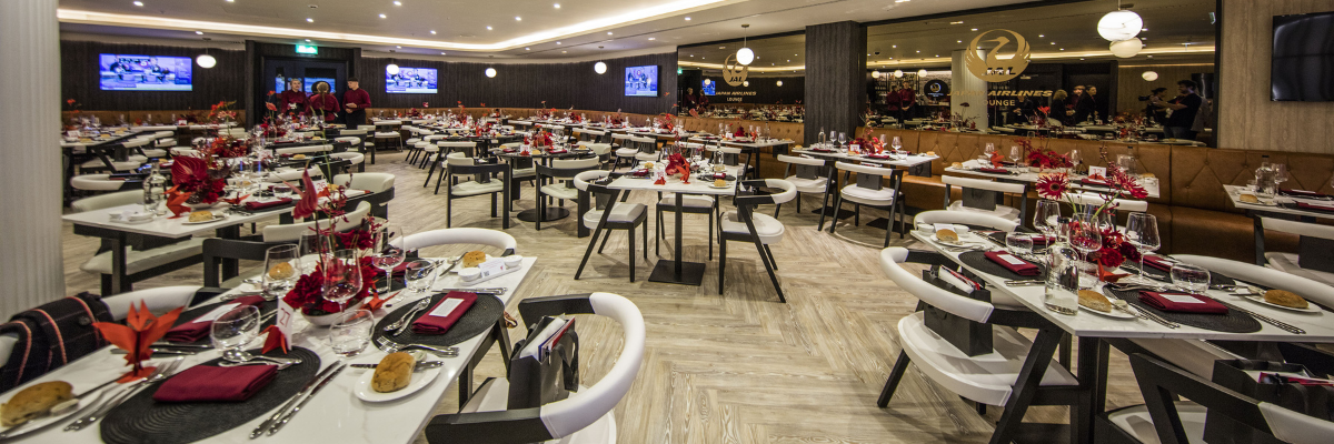 The completed Japan Airlines Lounge at Anfield stadium with modern dining tables and sophisticated interior design.