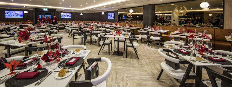 The completed Japan Airlines Lounge at Anfield stadium with modern dining tables and sophisticated interior design.