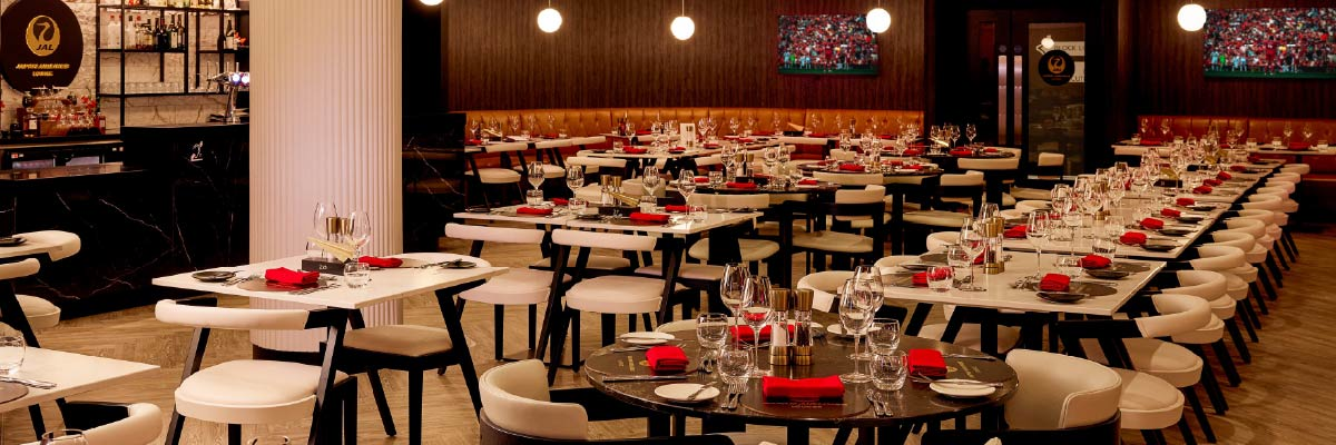 The completed Japan Airlines Lounge at Anfield stadium with modern dining tables and sophisticated interior design.