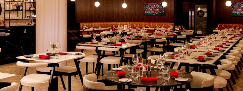 The completed Japan Airlines Lounge at Anfield stadium with modern dining tables and sophisticated interior design.