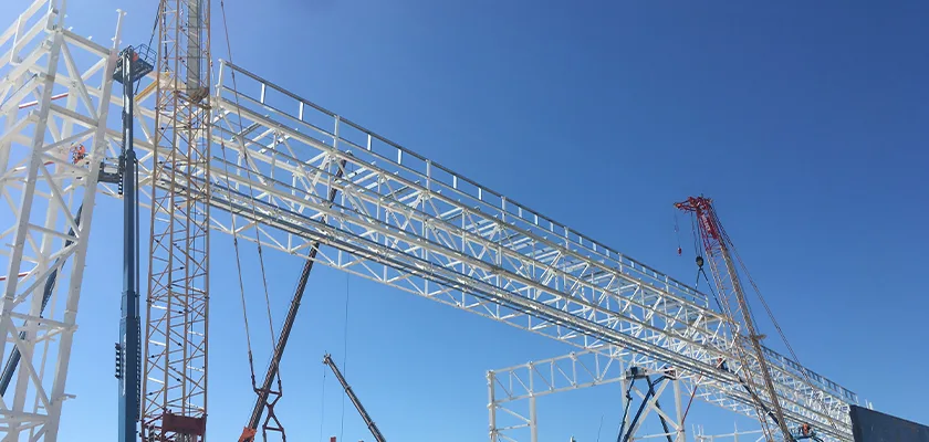 Cranes lift truss from assembly frames