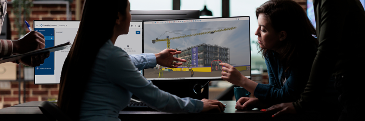 A team of AEC designers review a digital draft design of a 3D model on a desktop computer