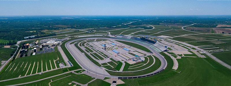 An aerial view of the tri-oval Kentucky Speedway in Sparta, Kentucky, with Trimble’s corporate blue wave branding across the top of the image.
