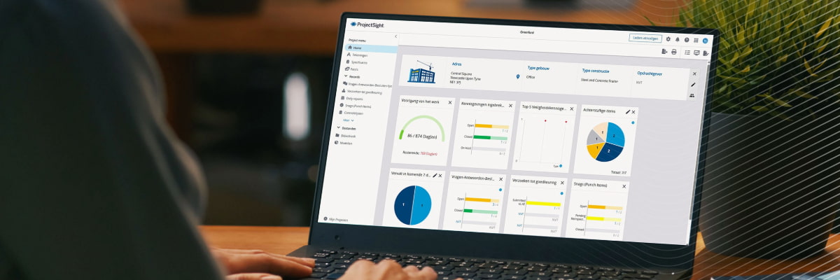 Op een laptopscherm wordt het ProjectSight-dashboard weergegeven met gegevens en grafieken over bouwprojecten.
