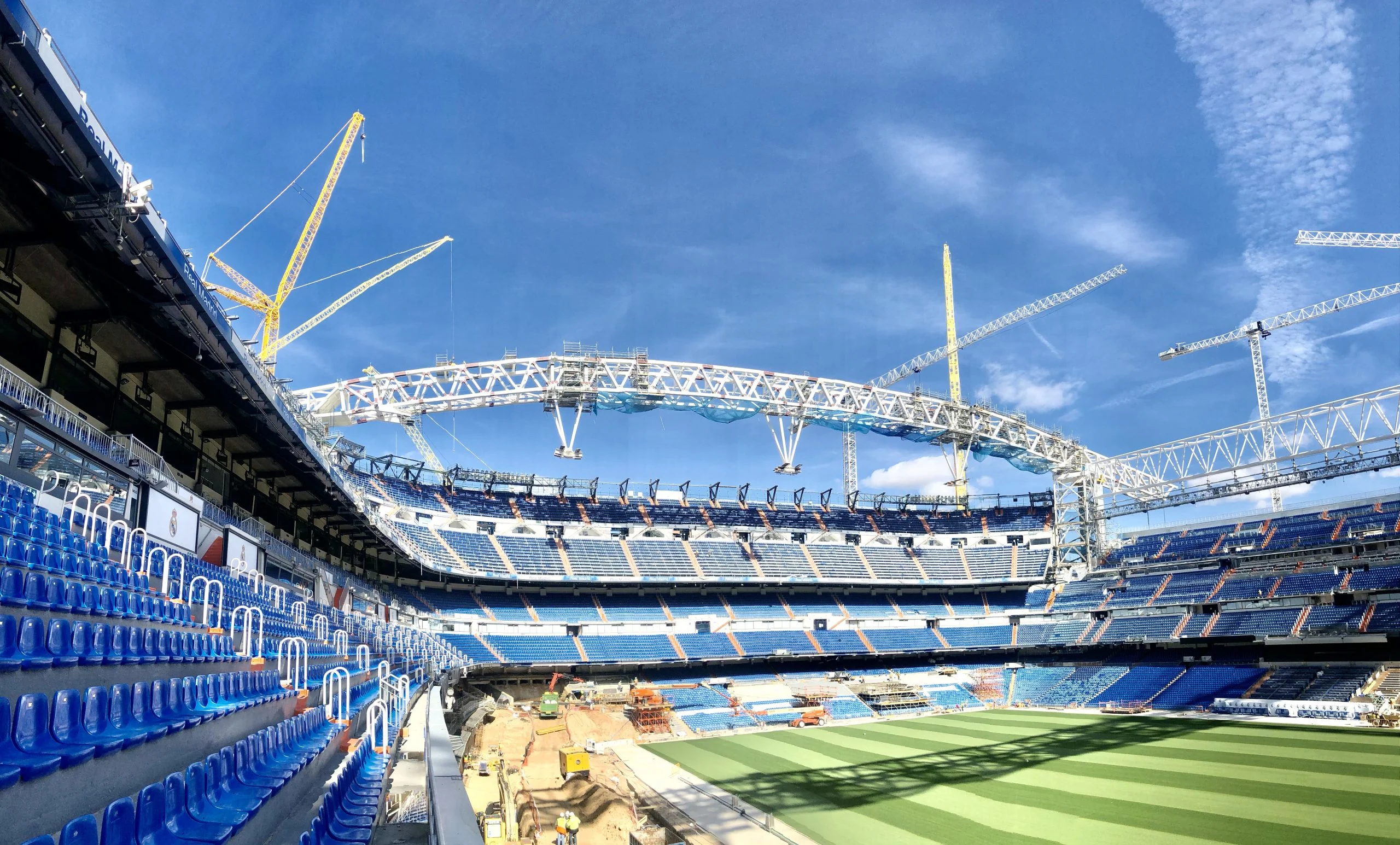 Santiago Bernabéu stadium under renovation with cranes and scaffolding.