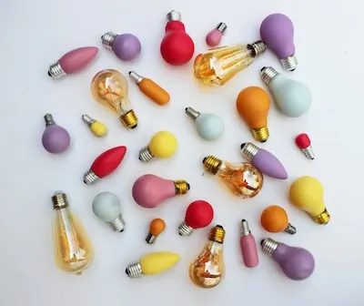 A collection of colorful, decorative lightbulbs arranged on a white background.