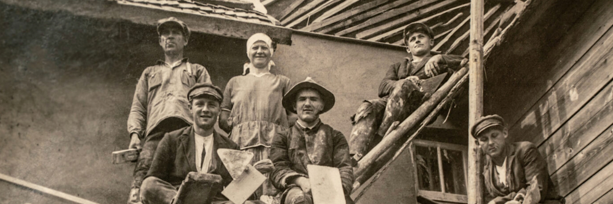 Builders sitting on scaffolding, 1920s.
